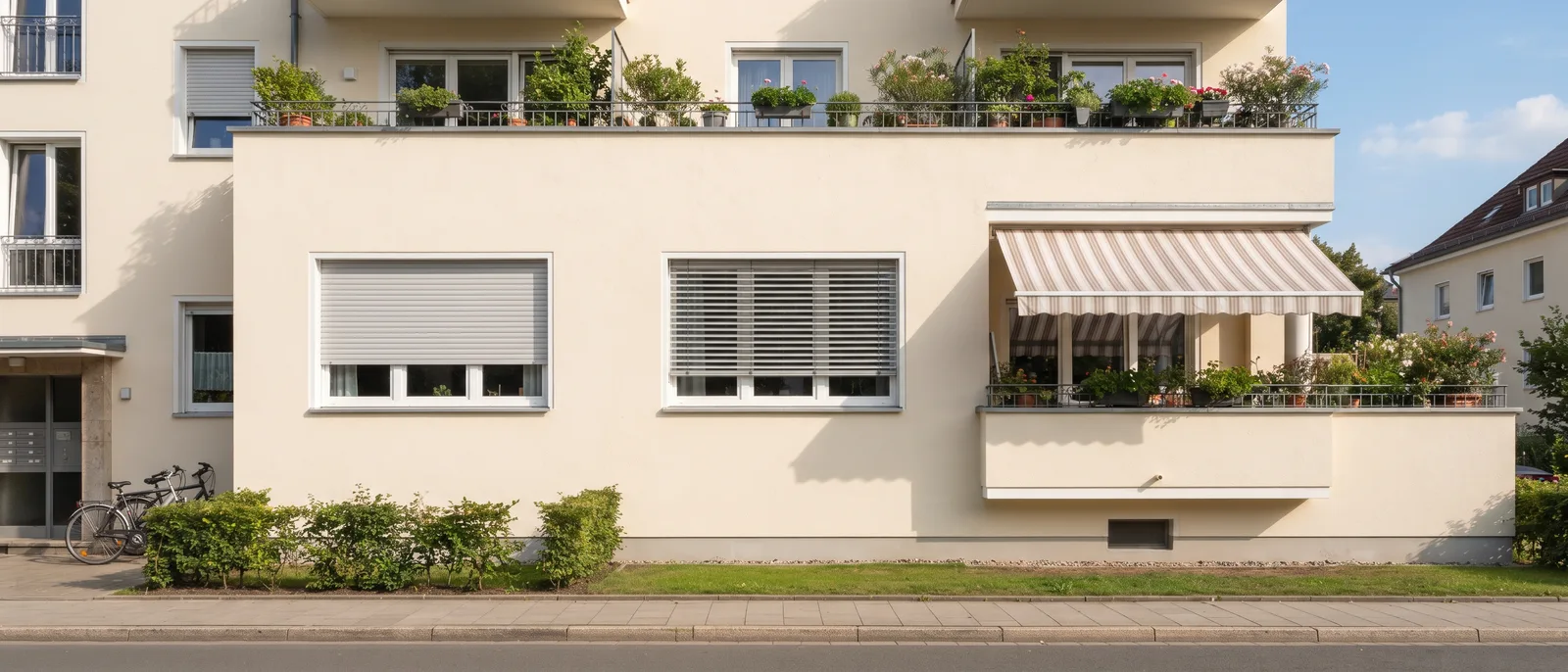 Hitzeschutz für Fenster im Vergleich: Rollladen, Raffstore und Markise an einer Fassade