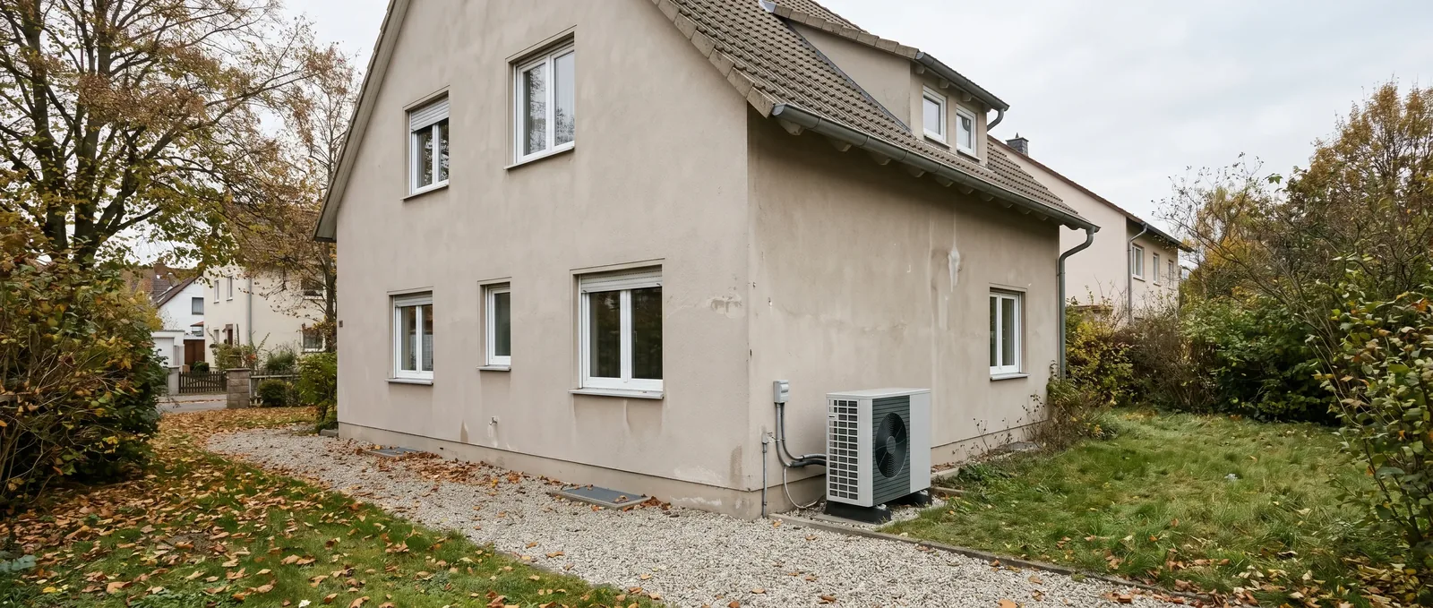 Monoblock-Wärmepumpe als Außeneinheit an einem verputzten Altbau mit gedämpfter Putzfassade